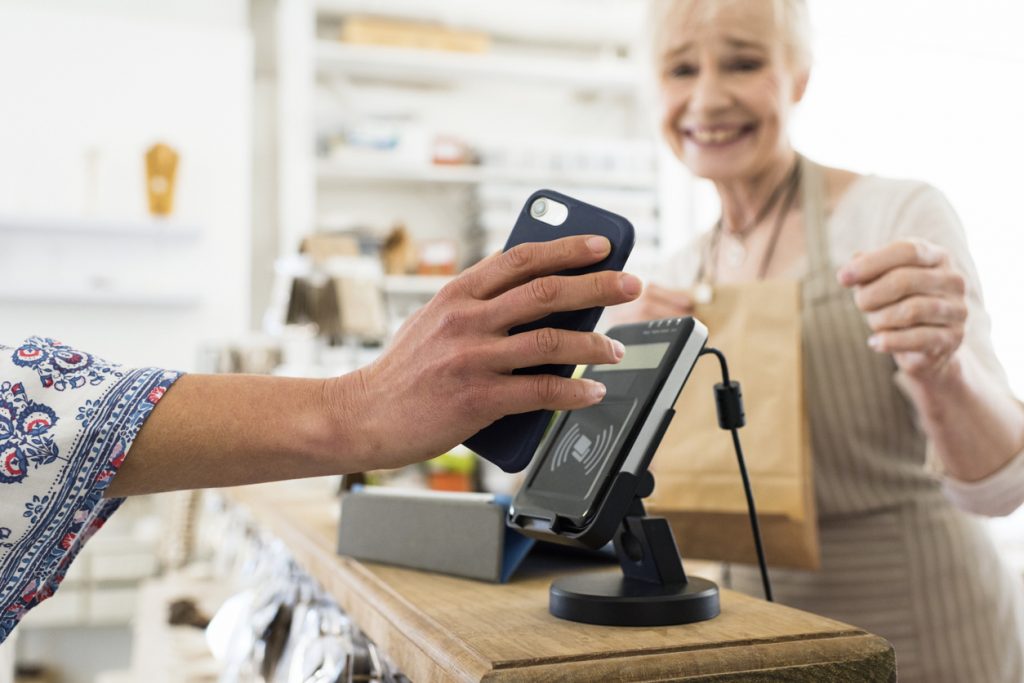 a woman uses her phone to pay in a store