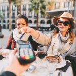 Tourist women in Barcelona paying contactless with credit card